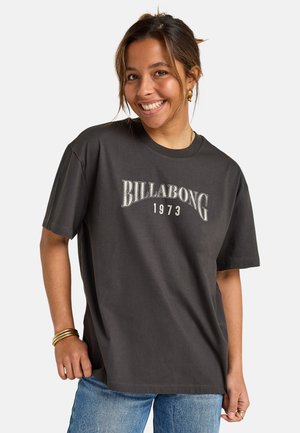 Donkergrijze katoenen T-shirt met "BILLABONG 1973" in witte letters. Loose fit, korte mouwen, met een ronde halslijn en zachte textuur.