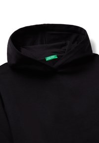 Černá mikina s kapucí vyrobená z měkké tkaniny, která má velkou kapuci a zelenou visačku s nápisem "UNITED COLORS OF BENETTON" na výstřihu.