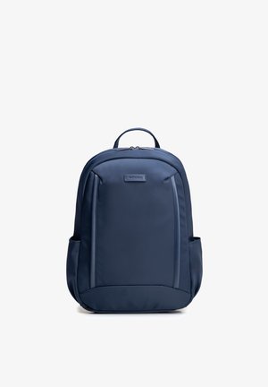 Granatowy plecak z dwoma bocznymi kieszeniami, zamykaną na zamek główną przegrodą, górnym uchwytem oraz metką marki WITTCHEN na przednim panelu.