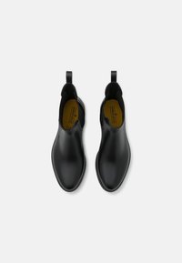 Bottines noires en cuir avec une finition lisse, panneaux élastiques sur les côtés et anses de tirage. Design de orteil effilé et arrondi pour une apparence élégante.