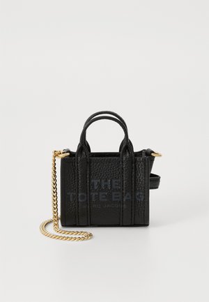Bolso mini tote negro hecho de cuero texturizado, con asas superiores, una correa de cadena dorada y una marca impresa en la parte frontal.