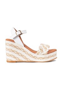 Sandalias de cuña blancas con detalles de yute trenzado, que cuentan con una correa para el tobillo y un área del dedo en forma de nudo, sobre una plantilla de color marrón texturizada.
