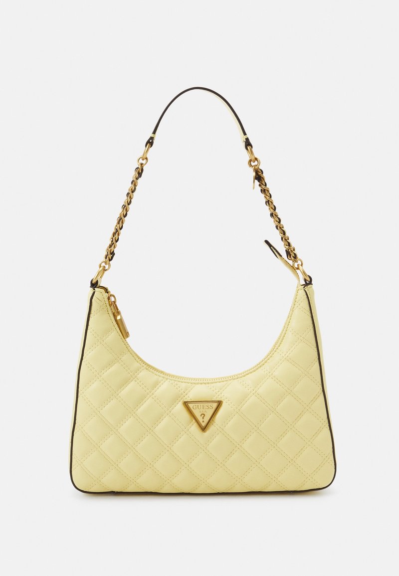 Petit sac à main matelassé jaune pâle avec bandoulière chaîne dorée et plaque logo Guess triangulaire à l'avant.