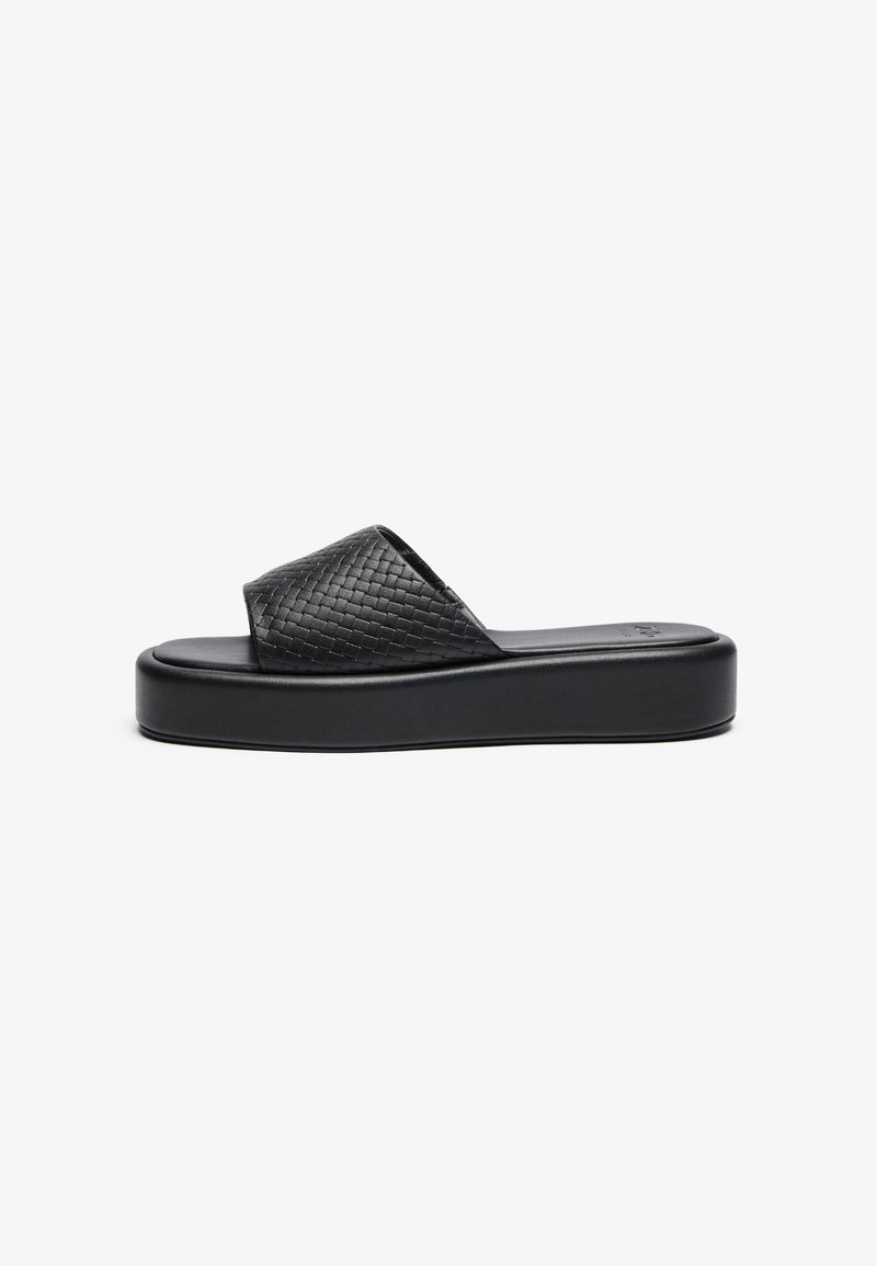 Black woven slide sandal with a thick platform sole and textured strap. Smooth footbed with a minimalist design.