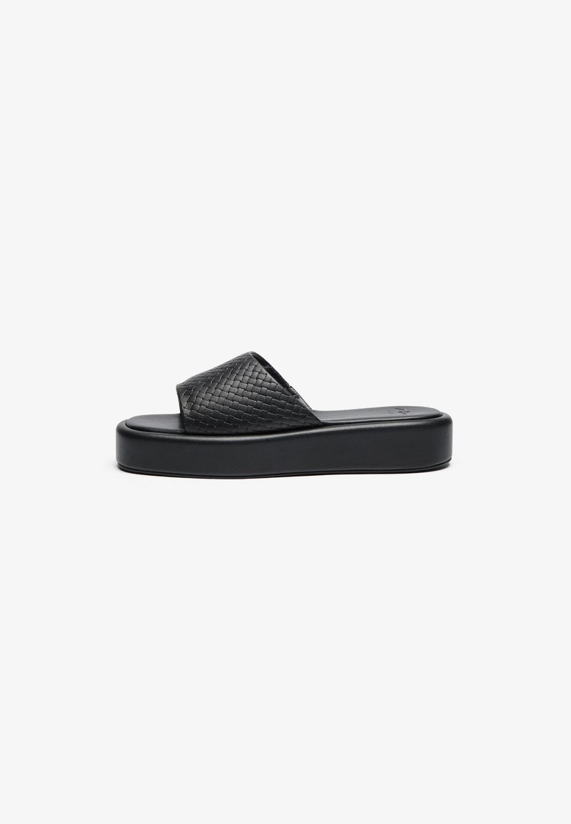 Sandal de deslizamiento negro tejido con una suela de plataforma gruesa y una correa texturizada. Plantilla suave con un diseño minimalista.