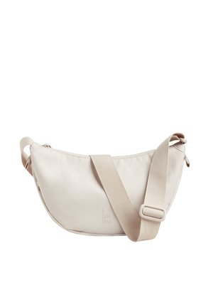 Beige fabric shoulder bag with a curved shape. Features a wide, adjustable strap and top zipper closure, with a subtle logo embossed on the side.
