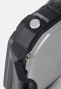 Black rugged case with a silver metal panel, round silver button, and textured accents. Features visible hardware and a strong edge design.