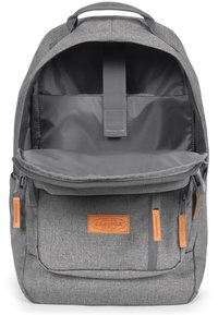 Zaino in tessuto grigio con scomparto principale con zip, tasca interna e dettagli in pelle sulle zip. Presenta spallacci imbottiti e maniglia per il trasporto.