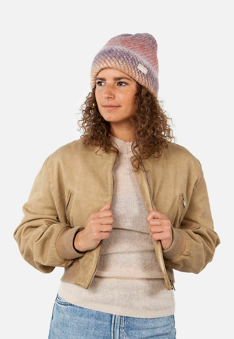 Tan bomber jacket with ribbed cuffs, a beige textured sweater, and a pink-lavender knit beanie. Jacket features zip closure and side pockets.
