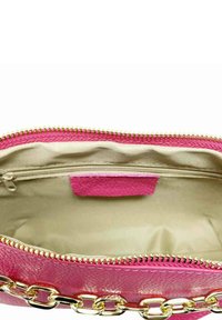 Interno di una borsa in pelle texturizzata rosa con fodera crema, zipper dorato e dettaglio a catena all'esterno. Contiene un piccolo scomparto con zip.
