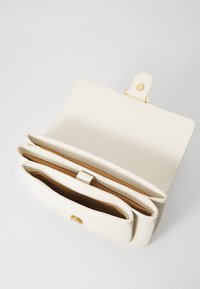 Borsa a mano bianca in pelle con finitura texturizzata, dotata di una chiusura a scatto dorata e tre scomparti separati all'interno.