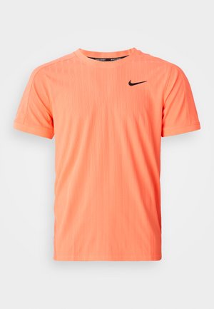 Short-sleeve, crew neck athletic shirt in bright coral with a textured fabric and black Nike logo on the upper left chest.