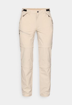 Beżowe spodnie outdoorowe z kieszeniami na suwak, regulowanym pasem i odpinanymi dolnymi częściami nogawek, wykonane z lekkiego, wytrzymałego materiału.