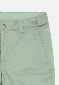 Világos zöld, vízálló North Face nadrág, állítható derékrésszel, oldalsó zsebbel és logóval ellátott fémbottonnal.