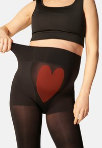 Zwarte leggings met een hoge tailleband, met een doorzichtige sectie en een rood hartpatroon aan de voorkant. Soepele textuur, nauwsluitend ontwerp.