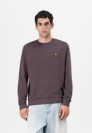 Sweatshirt violet foncé avec un col rond, des manches longues, des poignets et un ourlet côtelés. Présente un petit logo jaune sur la poitrine gauche.