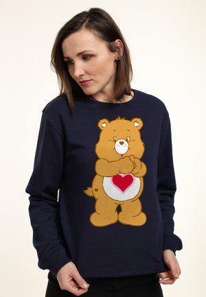 Marineblå sweatshirt lavet af bomuld med en tegneserie-bjørn med et hjerte på maven, blød tekstur, rund halsudskæring og lange ærmer.