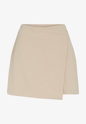 Mini-jupe beige style portefeuille avec une texture lisse et un ourlet légèrement asymétrique, conçue pour une tenue décontractée ou formelle.