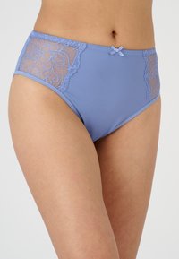 Lichtpaarse hoogwaist onderbroek met kant zijpanelen, een satijnen strikdetail aan de voorkant en een gladde, rekbare stofafwerking.