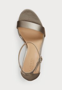Sandal metálico bronze com duas tiras largas, design de ponta aberta e uma tirinha fina no tornozelo. Material superior suave e palmilha acolchoada.