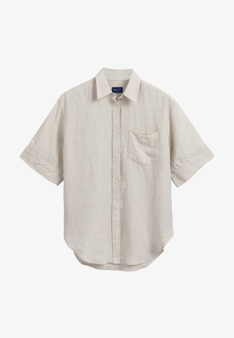 Chemise beige à manches courtes avec boutons, col et une poche poitrine, en tissu léger texturé.