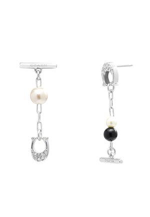 Boucles d'oreilles asymétriques en chaîne argentée avec perles et perles noires, l'une comporte des breloques fer à cheval incrustées de cristaux et des barrettes gravées Coach.