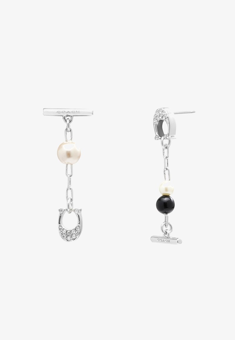 Boucles d'oreilles asymétriques en chaîne argentée avec perles et perles noires, l'une comporte des breloques fer à cheval incrustées de cristaux et des barrettes gravées Coach.