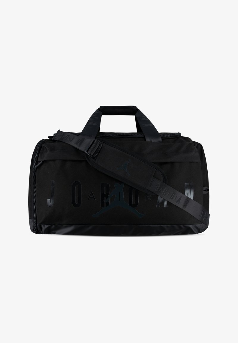 Svart treningsveske laget av solid stoff, med en stor "JORDAN"-logo og Jumpman-silhuett. Inkluderer doble håndtak og en justerbar stropp.