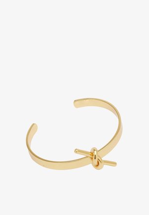 Złota metalowa bransoletka z gładkim wykończeniem, z prostym akcentem w formie węzła, który służy jako zapięcie, oferująca elegancki, minimalistyczny design.