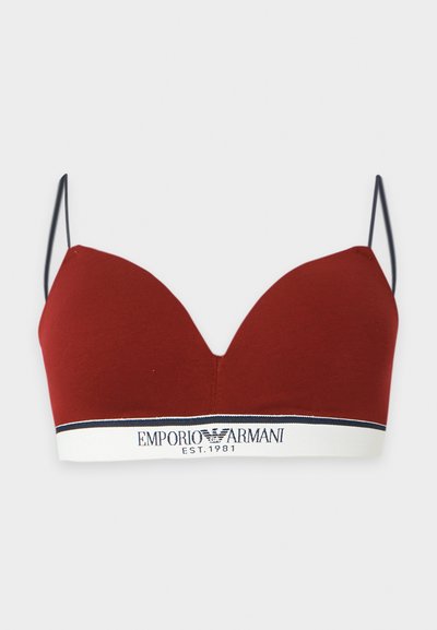 Κόκκινο bralette με λεπτές μαύρες τιράντες και λευκή ελαστική ταινία με το λογότυπο Emporio Armani και κείμενο "EST. 1981" σε μαύρη γραμματοσειρά.