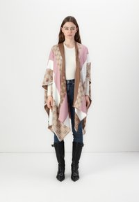 Poncho lavet i blødt stof med et geometrisk mønster i pink, beige og hvid, med frynset kanter og en løs pasform.