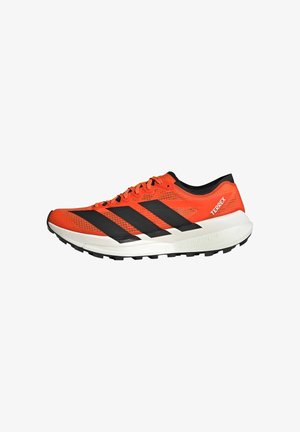 Fel oranje Adidas Terrex trailrunning schoen met zwarte strepen, witte gedempte zool en robuuste zwarte buitenzool voor grip.