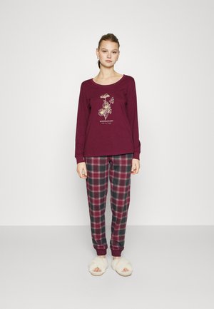 Maroon long-sleeve top with floral graphic and text, paired with plaid trousers in burgundy, green, and white, featuring a cuffed hem. White fluffy slippers.