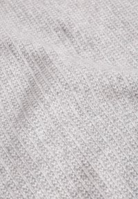 Tessuto lavorato a maglia grigio chiaro con una texture a coste, caratterizzato da sottili linee orizzontali e un aspetto morbido e accogliente.