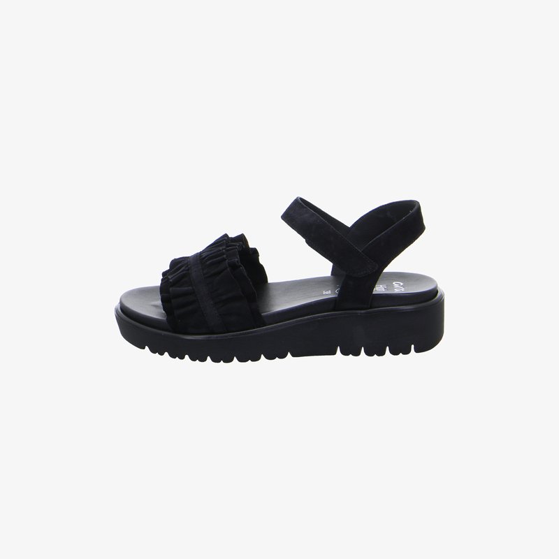 Black open-toe sandal with ruffled front strap, adjustable ankle strap, and thick, ridged sole.