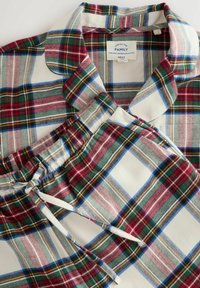 Plush plaid pajama set in red, green, and blue tones. Features a collared top and matching drawstring pants with elastic waistband.
