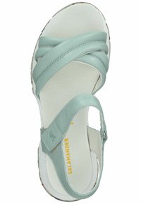 Sandal in pelle azzurro chiaro con multiple cinghie incrociate, cinturino alla caviglia regolabile e soletta bianca texture. Suola con motivo floreale.