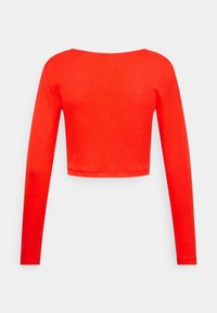 Top a maniche lunghe accorciato in tessuto a costine rosso brillante. Presenta una scollatura ampia e maniche aderenti, con una superficie complessiva liscia.