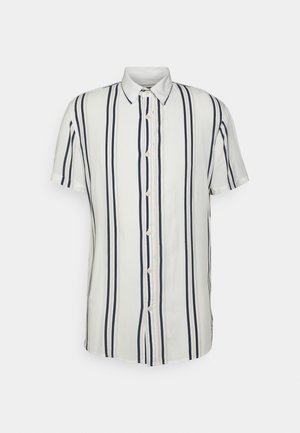 Camisa blanca de manga corta con botones, con rayas verticales en azul marino y beige y un cuello puntiagudo sobre un fondo simple.