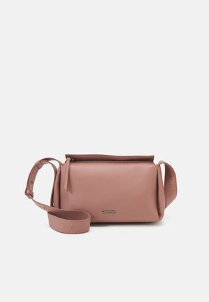 Sac bandoulière rectangulaire rose poudré avec sangle réglable, logo Calvin Klein en argent, et fermeture éclair supérieure sur fond blanc uni.