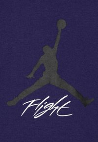 Fialová tkanina zobrazuje černou siluetu skákající postavy s basketbalem, doplněnou slovem "Flight" v bílé kurzívě.