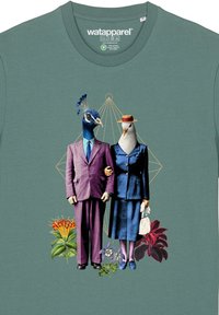 Teal t-shirt met een pauw en een pigeon in formele kleding, omringd door levendige bloemgraphics en geometrische ontwerpen.