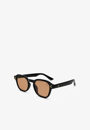 Schwarze rechteckige Sonnenbrille mit braunen Gläsern und kleinen goldenen Punktakzenten nahe den Scharnieren auf weißem Hintergrund.