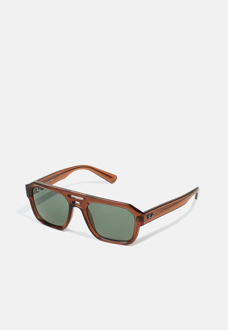 Ochelari de soare rectangulari transparenți, de culoare maro, cu lentile verzi. Caracteristici includ un cadru gros din plastic și accente metalice pe temple.