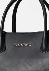 Geantă de piele neagră cu două mânere superioare, având un logo auriu "Valentino". Textură netedă, formă structurată, design minimalist.