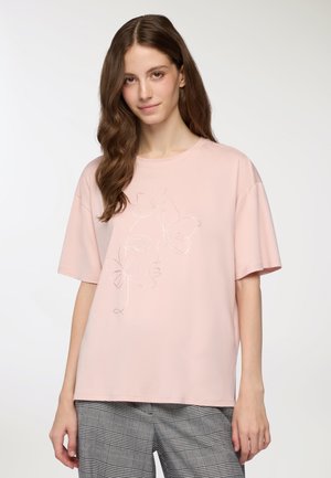 T-shirt rosa a maniche corte con vestibilità ampia, caratterizzato da una linea artistica argentata di un volto e fiori sulla parte anteriore, realizzato in tessuto morbido.