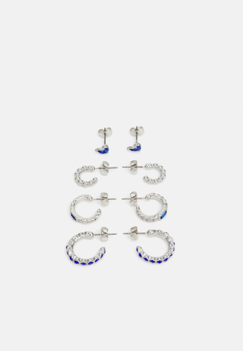 Conjunto de seis brincos em metal prateado. Inclui desenhos de pino e argola com gemas azuis e transparentes, variando em tamanho e forma.