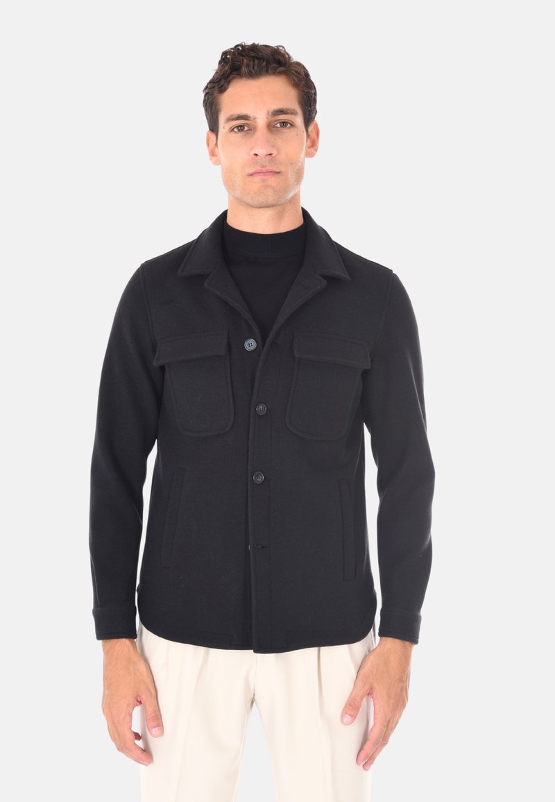 Giacca in misto lana nera con chiusura a bottoni, colletto e quattro tasche frontali. Presenta una vestibilità sartoriale e un design strutturato.