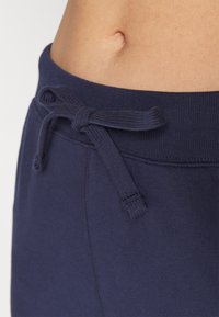Pantalons de jogging bleu marine en coton lisse, dotés d'une taille avec cordon de serrage et d'un bord plat.