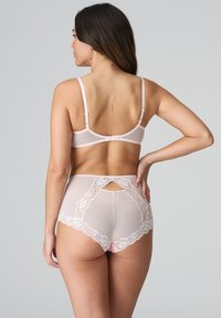 Jasnoróżowy zestaw bielizny składający się z przezroczystego stanika z regulowanymi ramiączkami oraz wysokich majtek ozdobionych koronkowymi detalami i wycięciem z tyłu.